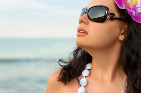 Portrait of the beautiful woman on seacoast. A profile, sun glassesの写真素材