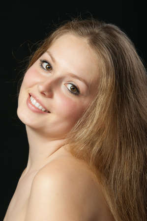 A portrait close up of the beautiful girl with long hair. On a black backgroundの写真素材