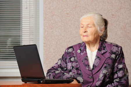 The elderly woman in front of the laptop. A photo in a roomの写真素材