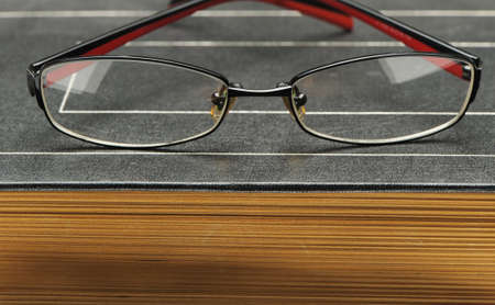 Eyeglasses on the old thick book. A photo close upの写真素材
