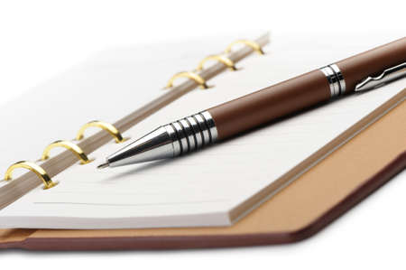 Open notebook with copper binding and stylish pen. It is isolated on a white backgroundの写真素材