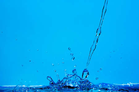 Splashes and water waves. Blue backgroundの写真素材