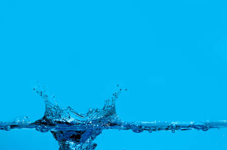 Splashes and water waves. Blue backgroundの写真素材
