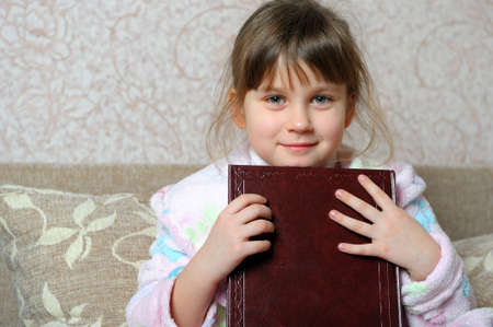 The little girl with the book. A house roomの写真素材