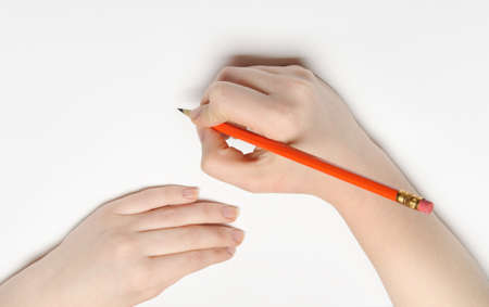 Hand with pencil. Over grey empty a paper. Imitation to writeの写真素材