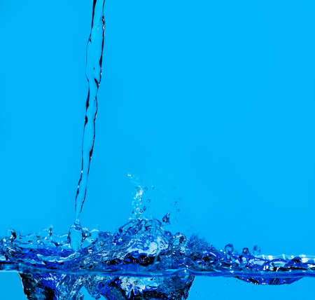 Splashes and water waves. Blue backgroundの写真素材