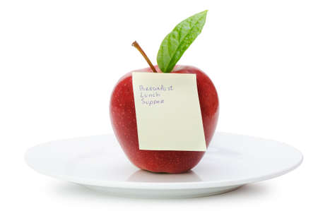 Apple with paper notes. Inscriptions on the notes Breakfast, lunch and dinner. The concept of dietの写真素材