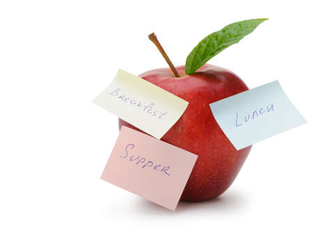 Apple with paper notes isolated on white. Inscriptions on the notes Breakfast, lunch and dinner. The concept of dietの写真素材