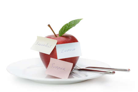 Apple with paper notes. Inscriptions on the notes Breakfast, lunch and dinner. The concept of dietの写真素材