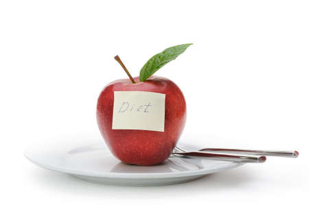 Apple with a paper note. Inscriptions on the notes diet. Fruit on a plate with a knife and fork isolated on white backgroundの写真素材