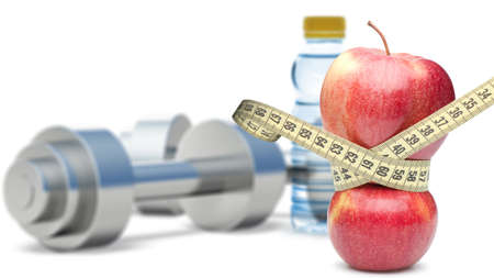 Dumbbells with an apple and measuring type. Dumbbells blured on a background. It is isolated on a white backgroundの写真素材