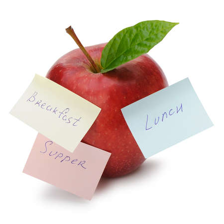 Apple with paper notes isolated on white. Inscriptions on the notes Breakfast, lunch and dinner. The concept of dietの写真素材