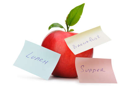 Apple with paper notes. Inscriptions on the notes Breakfast, lunch and dinner. The concept of dietの写真素材