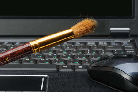 Brush and a laptop. The concept of computer artの写真素材