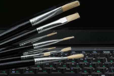 Brush and a laptop. The concept of computer artの写真素材