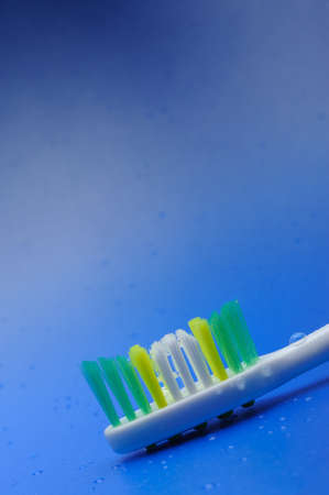 Toothbrush on a blue background with drops of waterの写真素材