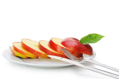 Apple sliced sections. Fruit on a plate with a knife and fork isolated on white backgroundの写真素材
