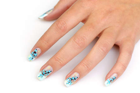 Female hand with manicure close up. Drawing of a branch with blue flowersの写真素材