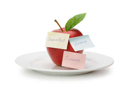 Apple with paper notes. Inscriptions on the notes Breakfast, lunch and dinner. The concept of dietの写真素材