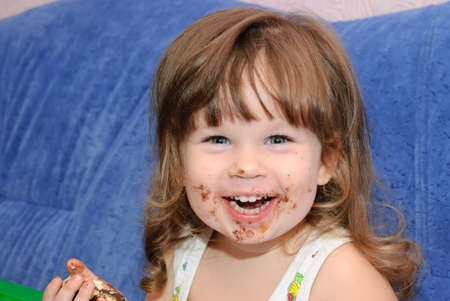 The little girl eats a cake. Funny pictureの写真素材