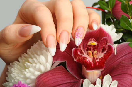 Female hands with manicure closeup. Against an orchidの写真素材
