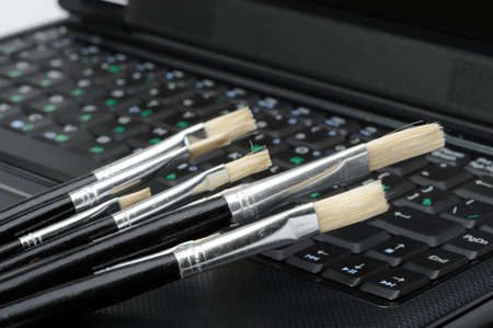 Brush and a laptop. The concept of computer artの写真素材