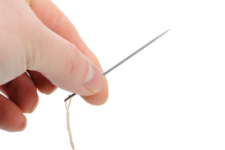 Needle and thread in hand closeup. Isolated on white backgroundの写真素材