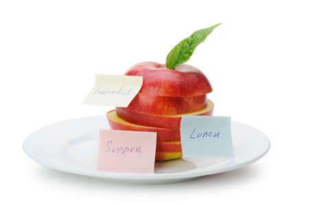 Apple sliced sections with paper notes. Inscriptions on the notes Breakfast, lunch and dinner. The concept of dietの写真素材