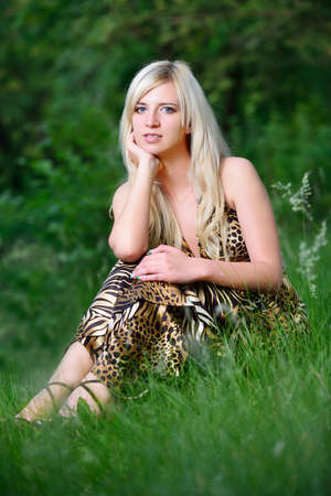 Portrait of a pretty woman sitting in the grass. Shooting outdoorsの写真素材