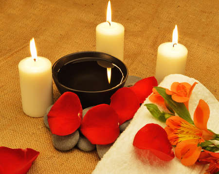Object for the spa. Candles burning, Pebble, Lily, liquid soap, a bottle with oil, bowl with the petals of roses in water, and another.の写真素材