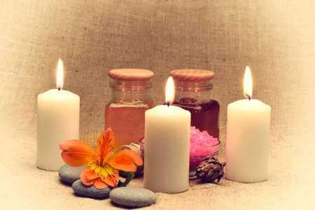 Object for the spa. Candles burning, pebble, a Lily, a bottle with oil.Retro tonedの写真素材