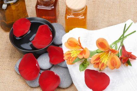 Object for the spa. Pebble, Lily, liquid soap, cupping glass with oil, bowl with the petals.の写真素材