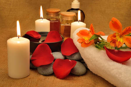 Object for the spa. Candles burning, Pebble, Lily, liquid soap, a bottle with oil, bowl with the petals of roses in water, and another.の写真素材