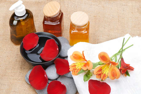 Object for the spa. Pebble, Lily, liquid soap, cupping glass with oil, bowl with the petals.の写真素材