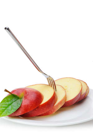 Apple sliced sections. Fruit on a plate with fork isolated on white backgroundの写真素材