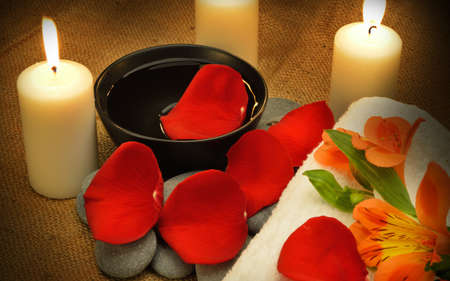 Object for the spa. Candles burning, Pebble, Lily, liquid soap, a bottle with oil, bowl with the petals of roses in water, and another.の写真素材
