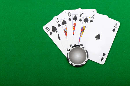 Gaming chips and cards on the green cloth. A winning combination in a poker Royal Flush