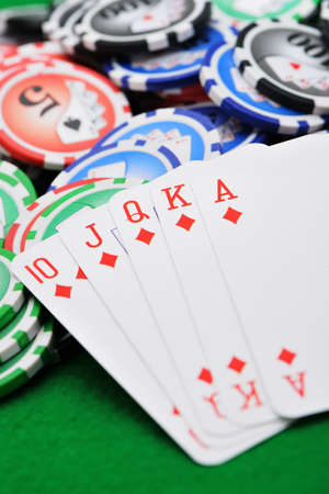 Gaming chips and cards on the green cloth. A winning combination in a poker Royal Flush