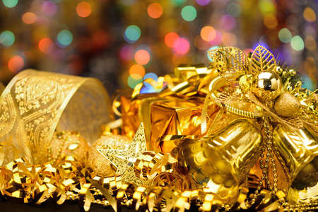 Gold Christmas decorations. Boxes, ribbons, stars, bells on the bokeh backgroundの写真素材