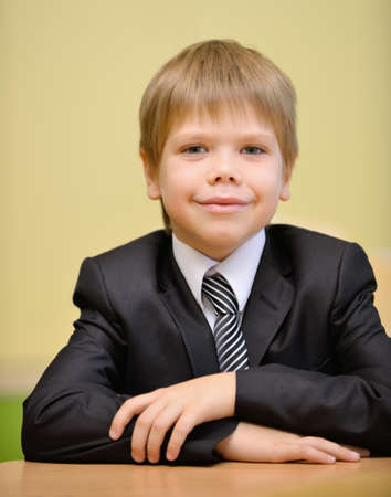 Schoolboy in a suit and tie. Sitting at a Deskの写真素材