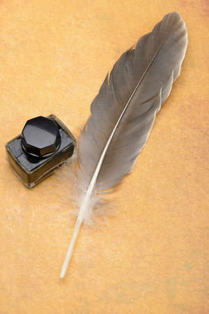 Feather pen on the old yellowed paper.Photo closeupの写真素材