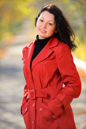 beautiful woman in a red cloak . Autumn Parkの写真素材