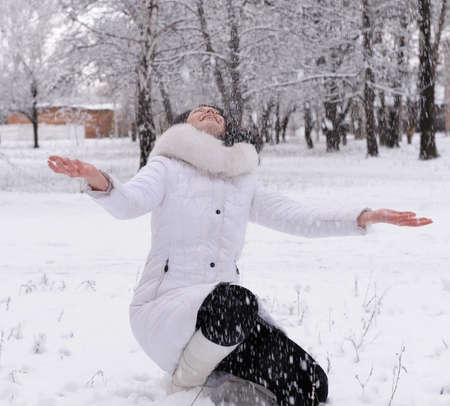 The woman in white and falling snowの写真素材