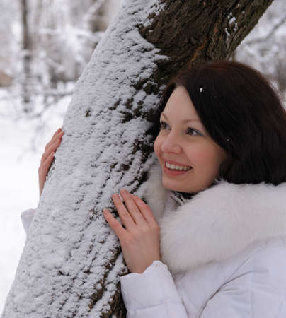 Portrait of the young woman in white at a tree. Winter timeの写真素材