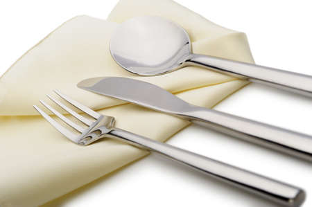 Spoon, fork and a knife lie on serviette. It is isolated on a white backgroundの写真素材