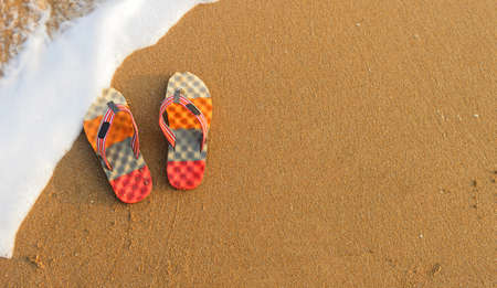 Colorful flip-flops on the sand. The shore of the Indian ocean