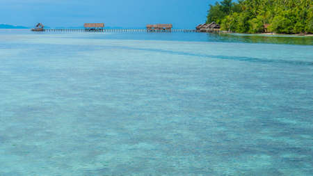Bay with Underwater Corals in Front of Diving Station and Guesthouses on Kri Island, Raja Ampat, Indonesia, West Papua.の写真素材