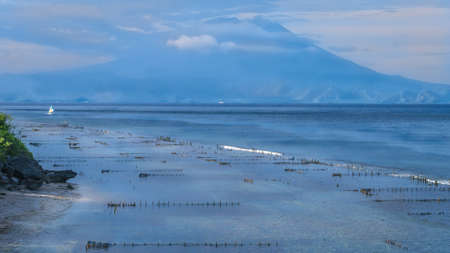 Beautifull evening view to St. Agung Vulcano on Bali from Nusa Penida Island. Partly Covered by Clouds. Indonesiaの写真素材