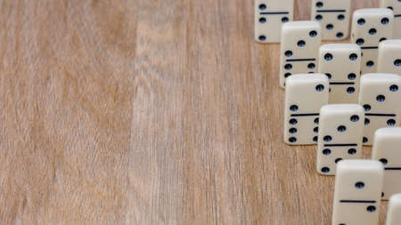 Parts of game of domino on wooden surface with empty space for textの写真素材
