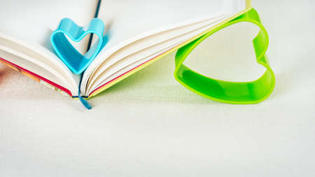 Blue and green hearts holding pages of open diary bookの写真素材